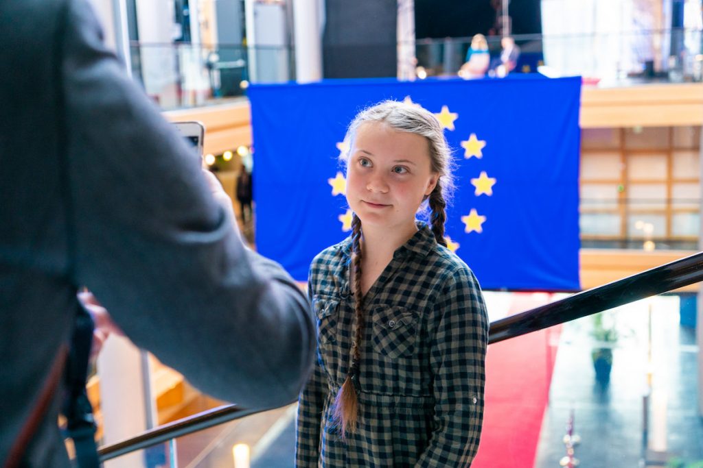 Young lady smiles in front of European Union flag